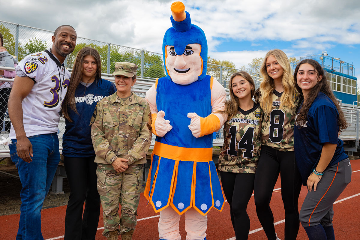 Connecticut girls and community members together at a football event