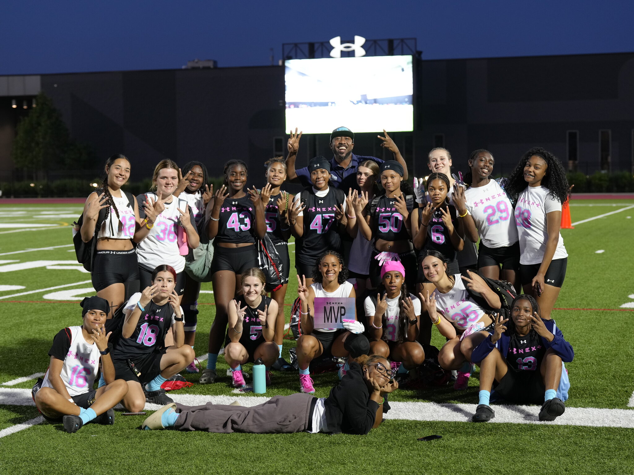 32 Sports girls and their coach celebrating together on the field